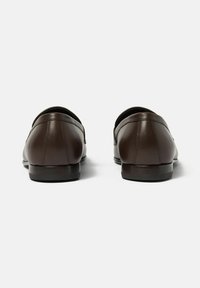 Braune Leder-Loafer mit glatter Oberfläche, abgerundetem Zehendesign und niedrigem, gestapeltem Absatz. Minimalistischer Stil ohne sichtbare Beschläge oder Akzente.