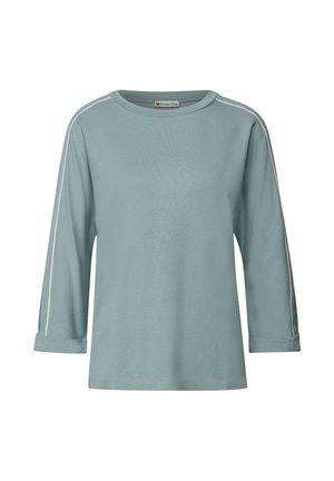 Chemise à manches longues bleu clair avec des passepoils blancs le long des manches et des poignets retroussés, dotée d'un col rond et d'une coupe décontractée.