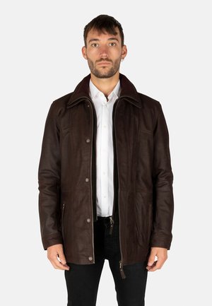 Brown leather jacket with a zip and snap button closure, featuring a pointed collar and side pockets, worn over a white shirt.