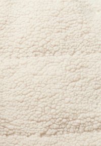 Tissu polaire doux couleur crème avec un aspect texturé, duveteux et confortable.
