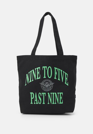 Černá plátěná taška s nápisem zeleným textem: "NINE TO FIVE PAST NINE" a kruhovým grafickým logem. Dlouhé dvojité popruhy a prostorný design.