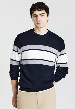 Maglione blu navy con strisce grigie e bianche, collo rotondo, polsini e orlo a coste. Texture liscia, design aderente e stile casual.