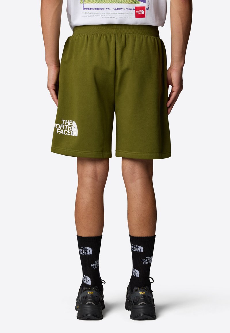 Pantalones cortos verde oliva de tela suave, con una cinturilla elástica y un estampado de logo blanco en la parte inferior izquierda.