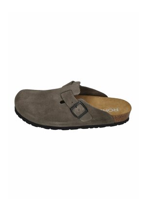 Brown suede slip-on clog with adjustable buckle strap, cork footbed, and black sole, designed for casual wear.