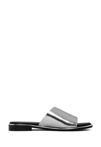 Metalen zilveren slide sandalen met een brede bovenband, platte zwarte zool en een strakke textuur. Het eenvoudige ontwerp benadrukt het reflecterende oppervlak.