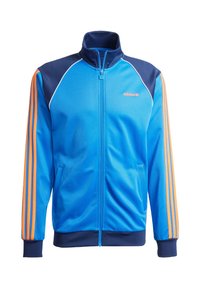 Sininen ja laivastonsininen Adidas-juoksutakki oransseilla raidoilla hihoissa, edessä vetoketju ja taskut, valkoisella taustalla.