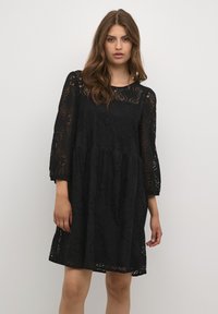Schwarzes Spitzenkleid mit rundem Ausschnitt, Dreiviertelärmeln und floralen Details. Lockere Passform mit ausgestelltem Saum.