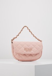 Różowa torebka z pikowanej skóry syntetycznej z paskiem na łańcuszku w kolorze złotym oraz wytłoczonym logo na przodzie, wyposażona w zapięcie na klapę.