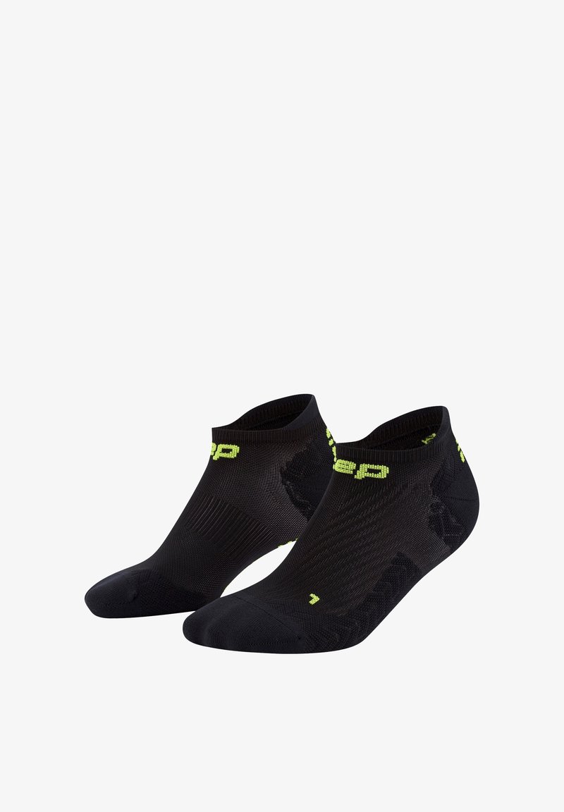 Schwarze Sportsocken mit einem niedrigen Schnitt, ausgestattet mit einer strukturierten Oberfläche und einem neongrünen Logo sowie Akzenten. Ideal für Sport und Freizeit.