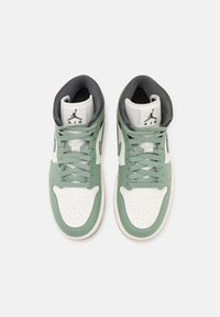 Vysoké tenisky s bílou koženou základnou a mátově zelenými překryvy, texturovanou špičkou a šedým polstrovaným límcem. Černé logo na jazyku.