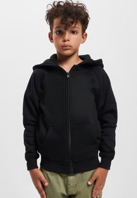 Hoodie noir zippé fabriqué en tissu doux, avec une capuche, des poches avant, des poignets côtelés et une coupe décontractée. Design et texture épurés.