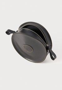 Round black leather bag featuring dual zippered compartments and yellow stitching. Includes a small handle on the side for easy carrying.