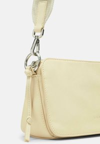 Bolso de cuero crema con un diseño estructurado, que presenta una superficie texturizada y herrajes en plata. Correa adjunta con un detalle de acento trenzado.