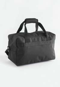 Zwarte stoffen duffelbag met dubbele handgrepen aan de bovenkant, ritssluiting en een afneembare schouderriem. Kenmerkt zich door een rechthoekige vorm en een gladde textuur.