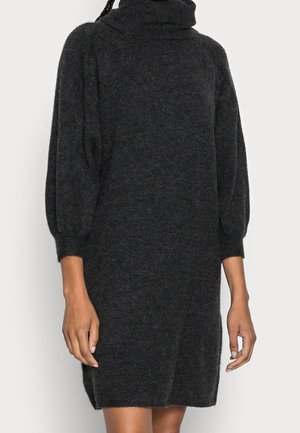 Robe tricotée gris foncé avec un col roulé haut, des manches ballon et une coupe décontractée. Texture douce, longueur genou et fentes latérales pour une liberté de mouvement.