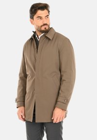 Cappotto impermeabile marrone con taglio dritto, colletto con revers, chiusura frontale con bottoni e tasche laterali. Il tessuto ha una texture liscia.