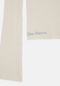 Maglione a coste lavorato a maglia di colore bianco sporco, con maniche lunghe e un sottile ricamo blu "Guess Originals" sull'orlo.