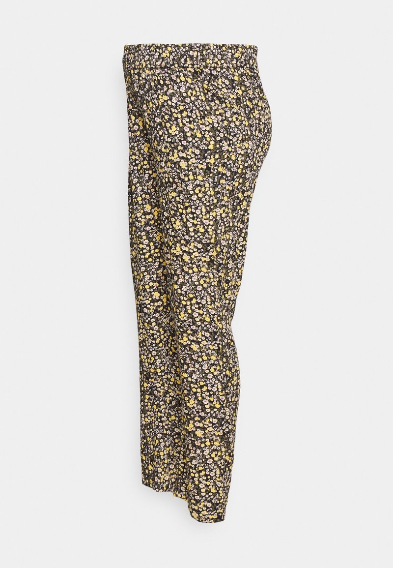 Pantalon noir ample avec petit imprimé floral jaune et blanc et taille élastique, vu de profil.