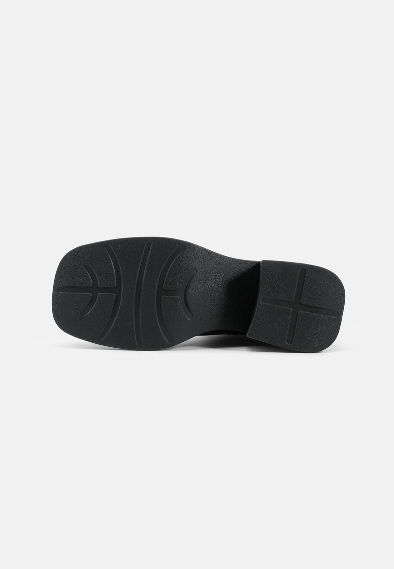 Suola nera di scarpa con motivo di grip testurizzato e tacco leggero; materiale in gomma solida; finitura liscia con curve e linee modellate.