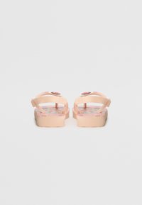 Chinelos cor-de-rosa com uma palmilha texturizada com um padrão floral. As tiras são suaves e flexíveis, projetadas para conforto e uso casual.