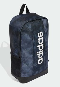 Blå og svart stoffryggsekk med en stor hvit Adidas-logo, med en glatt tekstur, strukturert form og mesh sidelommer.