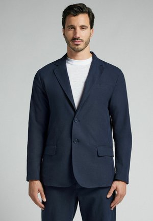 Blazer navy hecho de una mezcla de lino; cuenta con dos botones, solapas con muesca y dos bolsillos frontales; con frente plano y corte entallado.