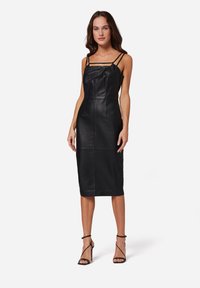 Schwarzes Leder-Midikleid mit verstellbaren Spaghetti-Trägern, tailliertem Oberteil und geradem Rock. Glatte Textur mit dezenten Nähten und Details.