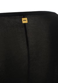 Tessuto nero dalla texture leggermente lucida, con un piccolo etichetta dorata che riporta la scritta "Manila Grace". Dettagli delle cuciture visibili lungo il lato.