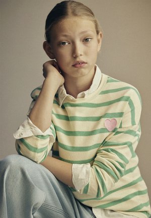 Lysegrønn og kremstripet genser med ribbede mansjetter, med en rosa hjertebrodering. Kombinert med lyse denimjeans.