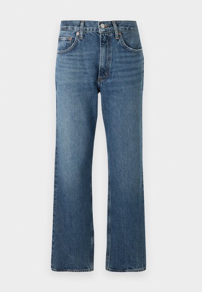 Farkut korkealla vyötäröllä ja levenevällä lahkeella. Keskisininen väri, jossa on hienovaraista kulumista, viisi taskua ja näkyvät tikkaukset.