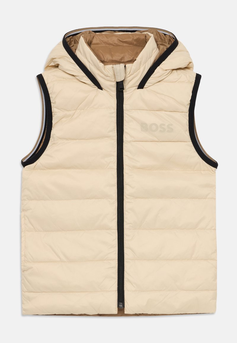 Beige puffer vest med hette, glidelås lukking og svart trim. Har quiltet tekstur og preget logo på brystet. Lett design.