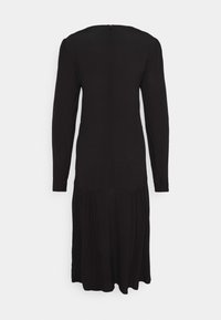Robe midi noire à manches longues avec une taille ajustée et une jupe basse froncée, vue de dos sur un fond uni.