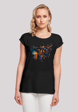 Schwarzes T-Shirt mit kurzen Ärmeln, das ein mehrfarbiges Schmetterlingsmotiv und das Wort "Frühling" in weißer Schrift zeigt. Weicher, lässiger Schnitt.