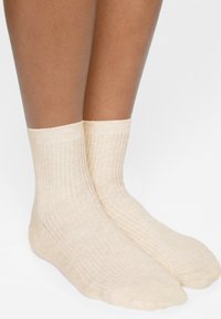Calze corte in cotone beige a costine con una texture morbida, dotate di un polsino rinforzato e punta senza cuciture per il massimo comfort.