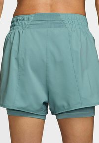 Pantalones cortos atléticos en un color azul claro con una cintura elástica, forro interior y costuras laterales, que presentan una textura de tela suave en todo su diseño.