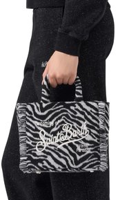 Sac à tote à rayures zèbre avec des bords frangés, gris et noir, présentant un texte brodé blanc : "Rêvant du paradis hivernal de Saint Barth."