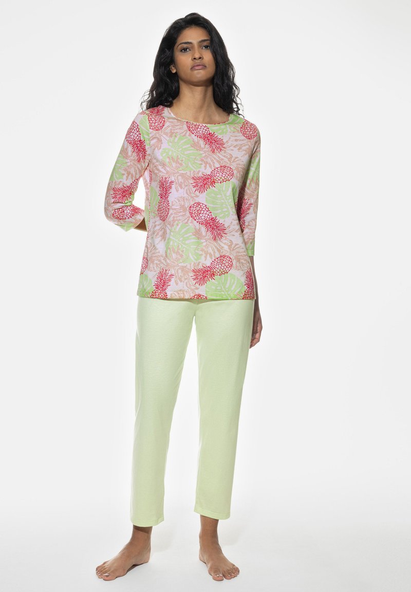 Cotton pajamas featuring a light pink top with red pineapples and green leaves, paired with light green pants, soft texture, casual design.