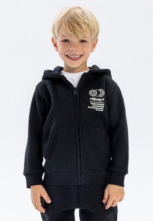 Black zip-up hoodie made of soft fabric features a kangaroo pocket, ribbed cuffs, and a white printed logo on the chest.