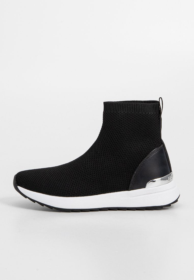 Baskets de cheville en tricot noir avec un dessus texturé, un accent de talon en cuir noir lisse et une semelle blanche avec un détail métallique à l'arrière.