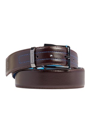 Donkerbruine leren riem met blauwe stiksels, zilveren gesp en lus, opgerold op een witte achtergrond.