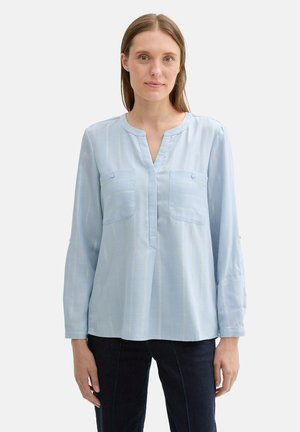 Light blue long-sleeve blouse with a straight cut, notch collar, two front pockets, subtle vertical stripes, and buttoned cuffs.
