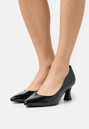 Escarpins en cuir verni noir avec bout pointu et talon bloc bas ; texture lisse et brillante avec un design à côtés ouverts.