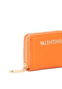 Portafoglio in pelle arancione con cerniera dorata e logo "VALENTINO" impresso sul davanti. Forma rettangolare compatta con texture liscia.