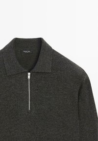 Maglione di lana grigio con collo con zip e spalle strutturate, dalla finitura liscia e testurizzata con una sottile lucentezza.