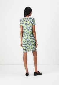 Robe à manches courtes de couleur vert clair, ornée d'un motif de papillons en bleu et violet. Tissu doux et extensible avec une silhouette ajustée.