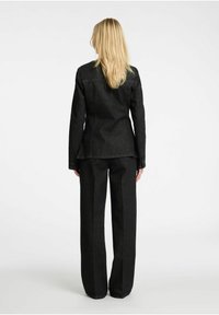 Svart jeansjacka och matchande byxor, skräddarsydd design med synliga s�ömdetaljer, raka ben och slät textur.