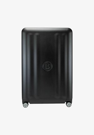 Zwarte harde koffer met verticale ribbels, logo in het midden en vier wielen voor mobiliteit. Gladde oppervlakte, rechthoekige vorm, compact ontwerp.