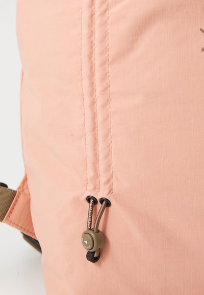 Rosa Rucksack mit horizontal gestreiftem Muster, verstellbarem Kordelzugverschluss mit schwarzem Band und hellbraunen Hardware-Details.