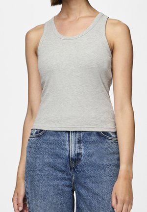 Débardeur côtelé gris clair avec un décolleté en forme de scoop et de larges bretelles, associé à un jean en denim bleu taille haute.