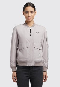 Svijetlo siva bomber jakna s patentnim zatvaračem sprijeda, rebrastim manžetama, dva velika prednja džepa i jednim džepom s patentnim zatvaračem na rukavu. Glatki, lagani materijal.